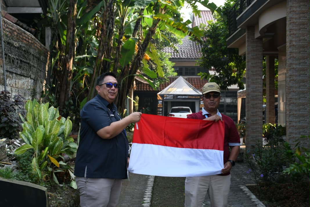 Kepala DPMD Kabupaten Bogor, Hadijana (kanan) bersama Camat Cigombong dalam pembagian bendera Merah Putih (Istimewa)